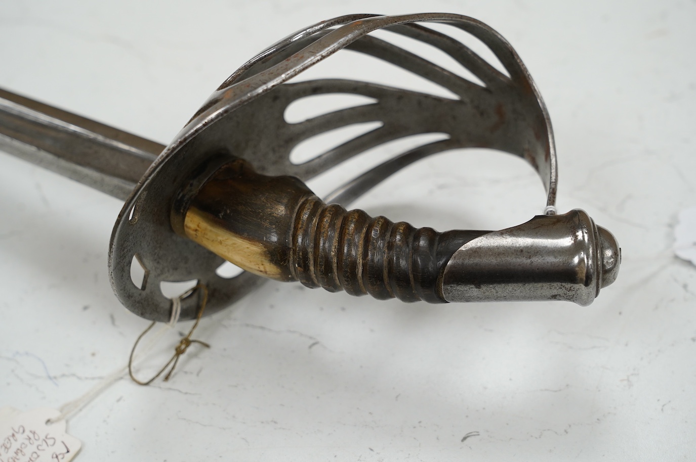 An 1880s French cavalry sword with horn grip and seven bar pierced steel guard, blade 88cm. Condition - fair